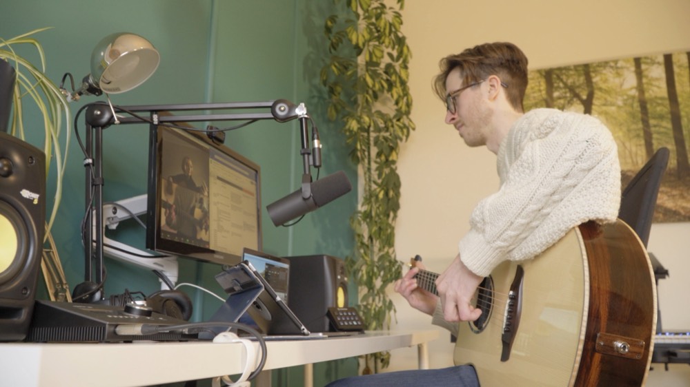 Matthew's online teaching setup: monitor, microphone and guitar